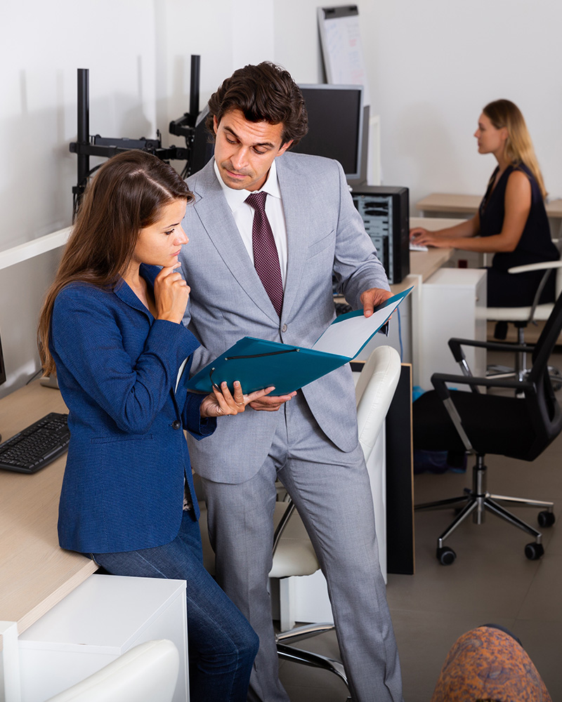 A business office with employees working on computers connected to a visible wired or wireless network, focusing on a professional setup.